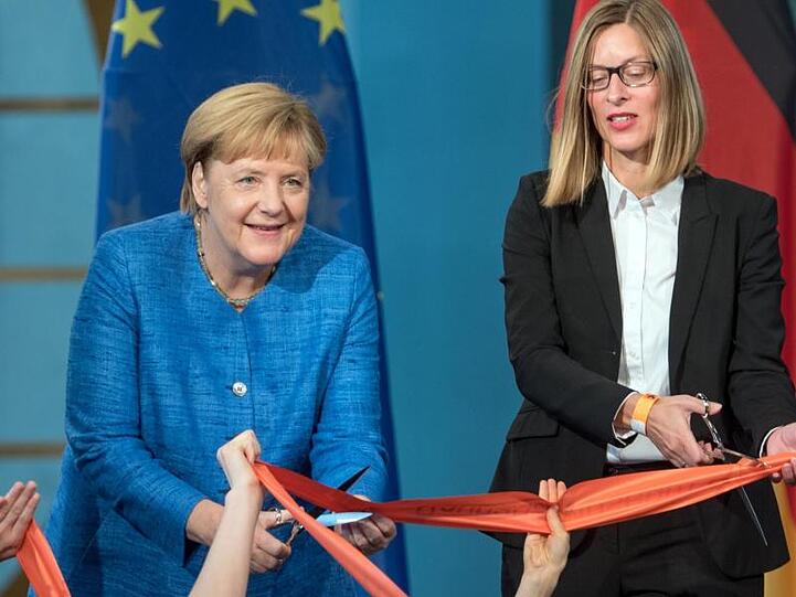 Bundeskanzlerin Angela Merkel (CDU, l) und Claudia Perren, Direktorin der Stiftung Bauhaus Dessau, zerschneiden zur Eröffnung des Bauhaus Museums Dessau ein rotes Band.