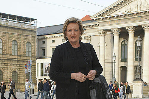 Wiest im eleganten schwarzehn Kostüm vor der Oper
