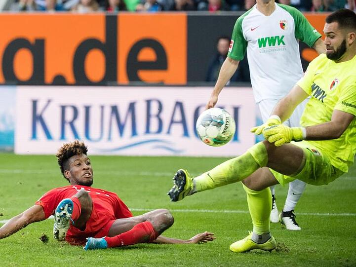 Tomas Koubek von Augsburg (r.) kann den Ball von Kingsley Coman vom FC Bayern München abwehren. Foto: Matthias Balk/dpa