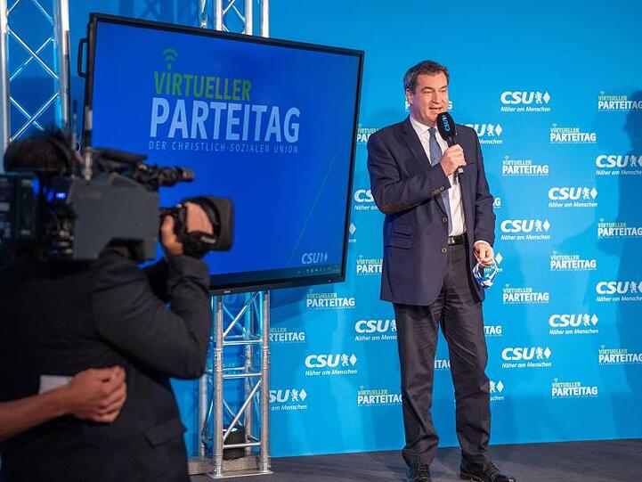 Markus Söder (CSU) steht beim virtuellen CSU-Parteitag auf einer Bühne. Foto: Lino Mirgeler/dpa-Pool/dpa