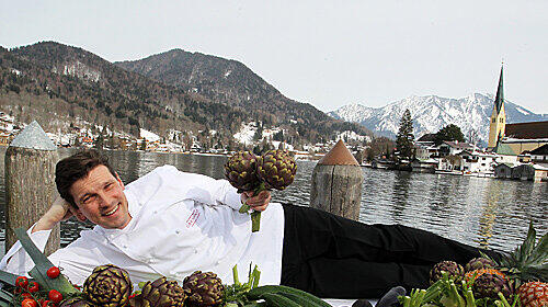Doppelte Idylle: Im Hintergrund der Malerwinkel in Rottach-Egern, vorne Sternekoch Christian Jürgens mit einem Vitamin-Mix aus Obst und Gemüse. Ab Montag serviert er die AZ-Gourmet-Diät.