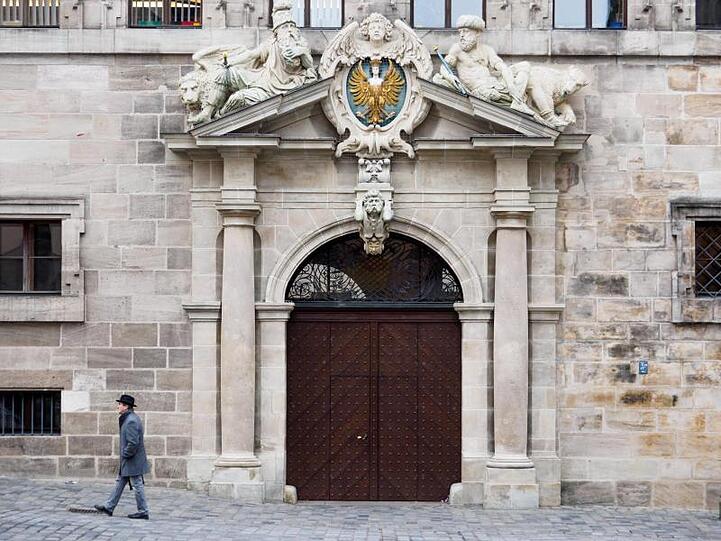 Ein Mann geht am Alten Rathaus in Nürnberg vorbei. Foto: Nicolas Armer/Archivbild