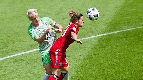 Münchens Nicole Rolser (r) köpft den Ball vor Wolfsburgs Nilla Fischer weg. Foto: Rolf Vennenbernd/Archiv