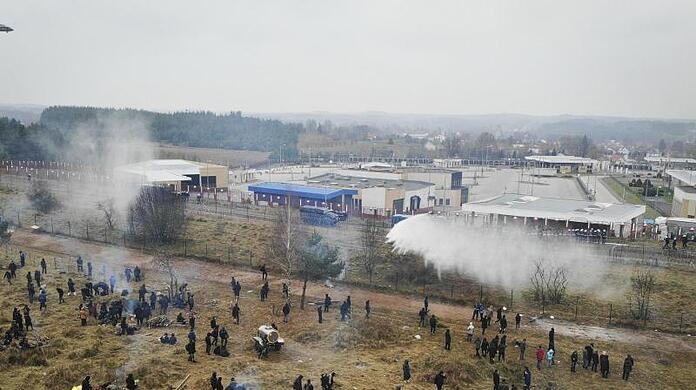 Polnische Grenzsoldaten setzen Wasserwerfer gegen Migranten ein.