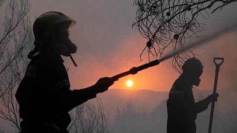 Feuerwehrleute kämpfen gegen die Flammen.