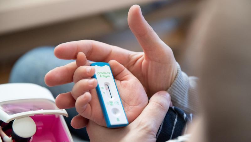 Ein Kita-Kind und seine Mutter warten daheim auf das Ergebnis eines Corona-Selbsttests.
