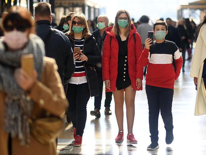 Menschen tragen zur Prävention vor dem Coronavirus einen Mundschutz. Foto: Daniele Mascolo/XinHua/dpa/Archiv