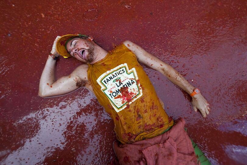 Mittagsschlaf im Tomatenmatsch: Dieser verausgabte Tomatina-Fan hat sogar ein passendes T-Shirt an.