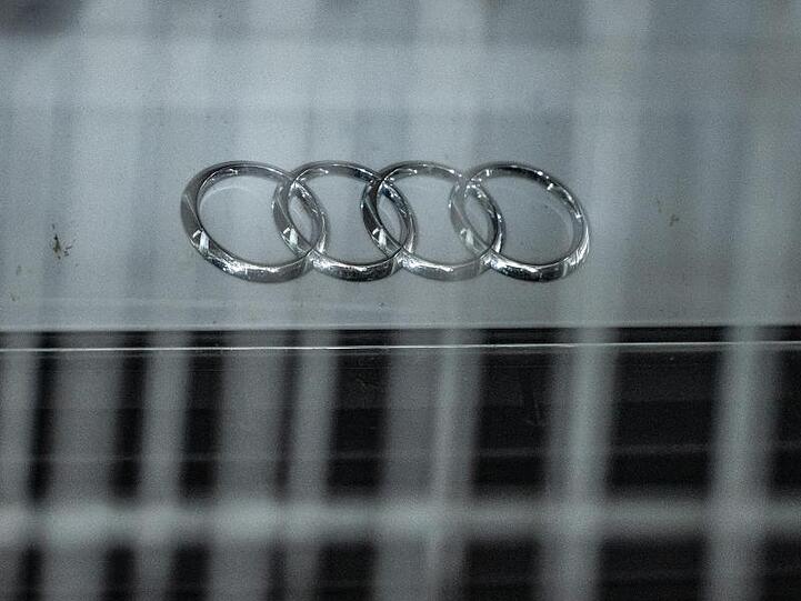 Hinter einem Metallzaun steht ein Audi mit dem Logo des Autoherstellers auf der Motorhaube. Foto: Armin Weigel/Archiv