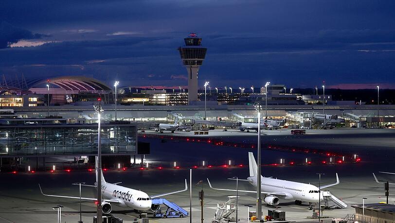 Flugzeuge stehen vor Sonnenaufgang auf dem Flughafen Franz-Josef-Strauß.