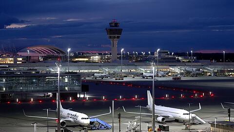Flugzeuge stehen vor Sonnenaufgang auf dem Flughafen Franz-Josef-Strauß.