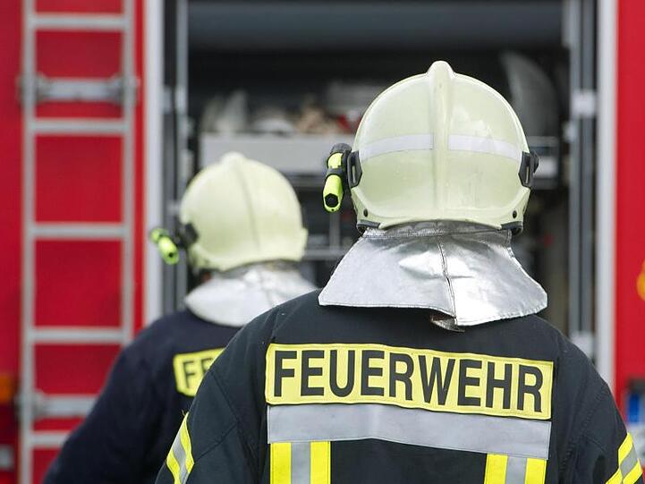 Einsatzkräfte der Feuerwehr stehen vor einem Feuerwehrauto. Foto: Stefan Sauer/zb/dpa/Archiv