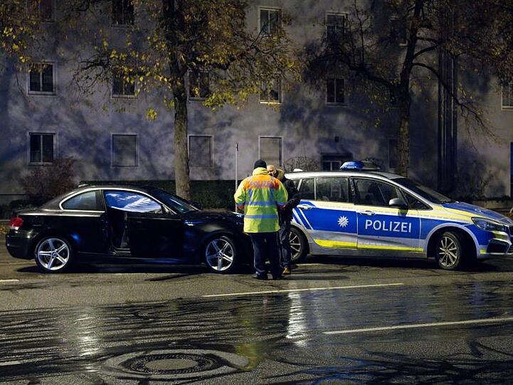 Polizisten stehen nach einem Unfall auf der Fürstenrieder Straße neben einem beschädigten Auto. F. Foto: Sven Hoppe/dpa