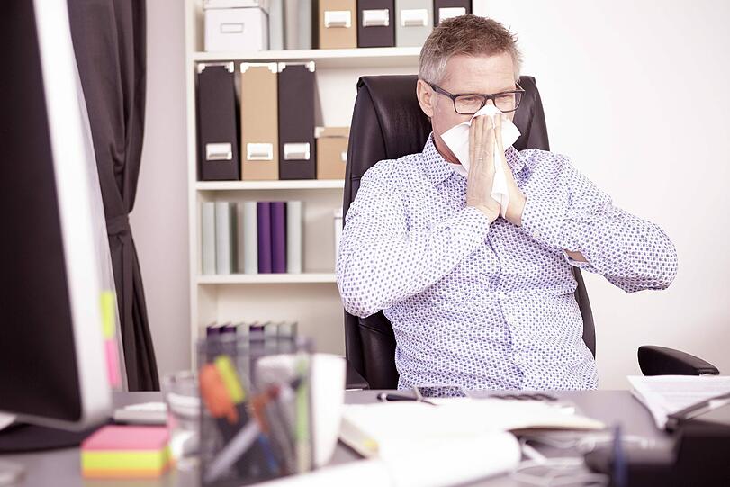 Viele Menschen gehen trotz eines grippalen Infekts ins Büro. Ob das sinnvoll ist, sei dahingestellt.