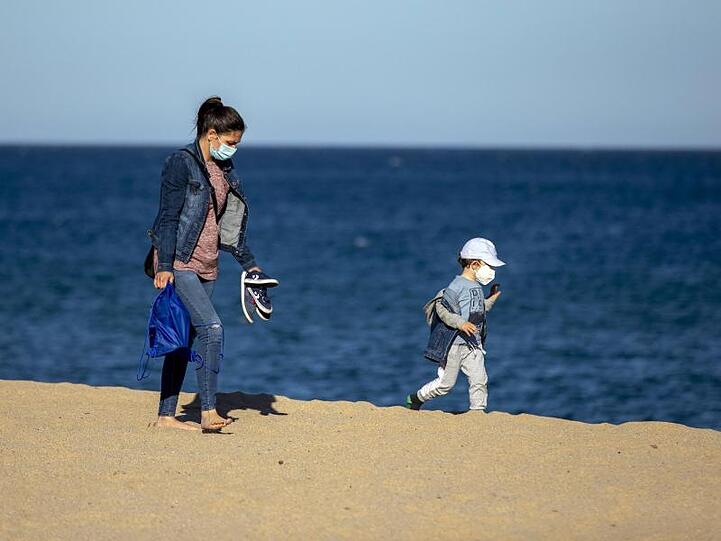 Eine Frau und ihr Sohn an einem Strand in der Nähe von Barcelona in Spanien.