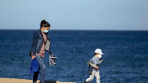 Eine Frau und ihr Sohn an einem Strand in der Nähe von Barcelona in Spanien.