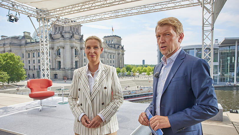 Alice Weidel (AfD), Parteivorsitzende, und Moderator Markus Preiß kommen zum ARD-Sommerinterview "Bericht aus Berlin" gegenüber vom Reichstagsgebäude.