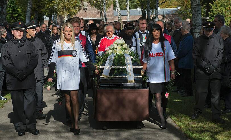 Trauergäste, darunter Hallers Tochter Karin (vorn,r), begleiten den Sarg.