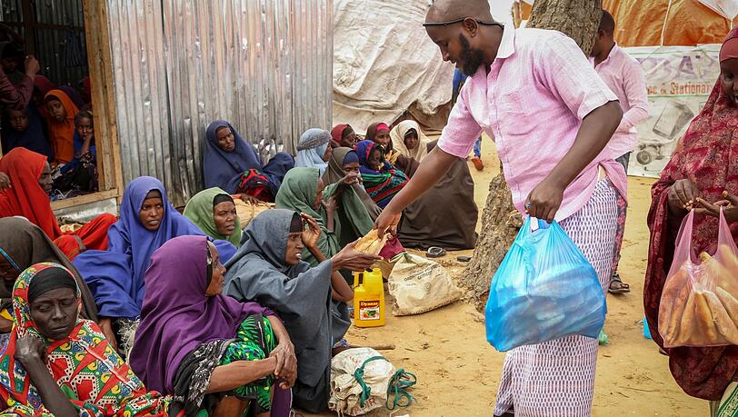 An Somalier, die vor der Dürre geflohen sind, werden am Rande der Hauptstadt Mogadischu Lebensmittelspenden verteilt.