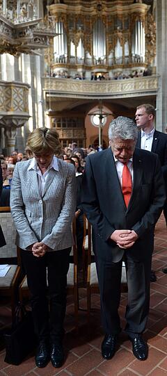 Gemeinsam mit seiner Lebensgefährtin Daniela Schadt (mitte) und dem sachsen-anhaltinischen Ministerpräsident Reiner Haseloff (CDU, links) betet Bundespräsident Joachim Gauck (rechts) in der Marktkirche von Halle. Die Bilder.