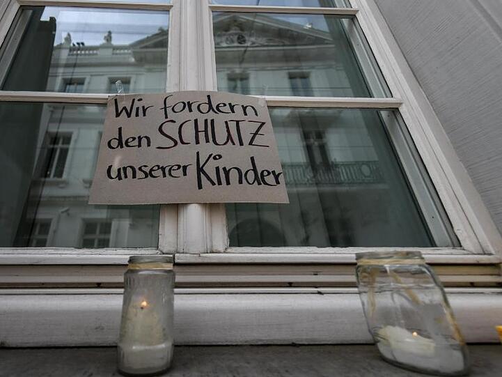 Mitglieder der Initiative "Aktiv gegen Missbrauch" halten mit Bannern vor dem Landgericht in Freiburg eine Mahnwache.