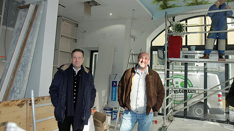 Constantin Wahl (l.) und Sebastian Kuffler im künftigen Salettl, der Schwemme mit 80 Plätzen an Hoch- und Stehtischen. Das große Fenster rechts war zuletzt zugemauert. An der Decke stellt ein Maler die Lüftlmalerei fertig.