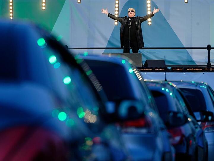 Der Sänger Heino steht bei einem Auto-Konzert auf der Bühne.