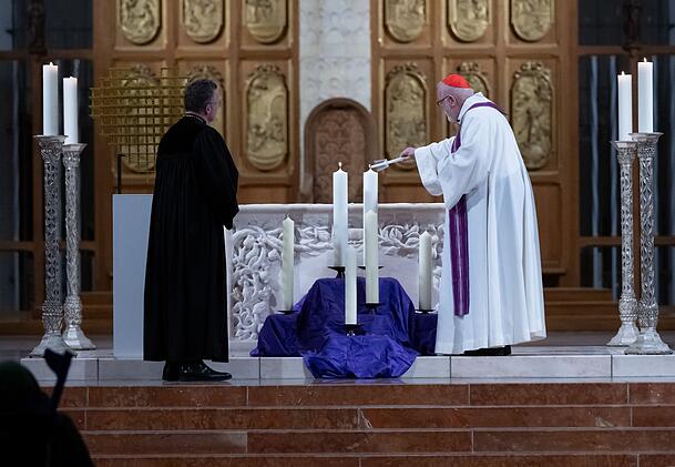 Kardinal Reinhard Marx (r.), Erzbischof von München und Freising, entzündet zwei Kerzen in der Münchner Frauenkirche für die beiden Opfer des Anschlags.