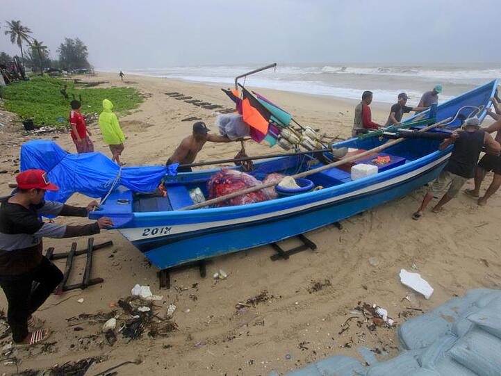 Vorbereitung auf den Tropensturm "Pabuk": Männer schieben in Songkhla ein Fischerboot an einen sichereren Ort.