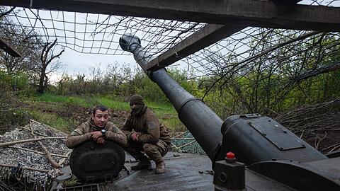 Ukrainische Soldaten schauen aus einer Panzerhaubitze.