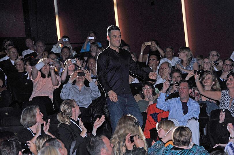 Weltstar im Fan-Gewusel: Robbie Williams verteilte Autogramme vor dem Mathäser-Kino.