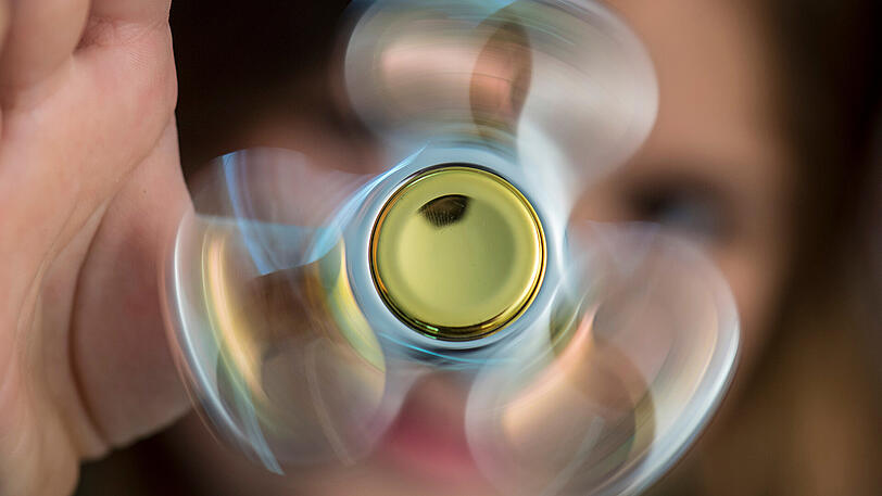 Ein Kind spielt mit einem Fidget Spinner.