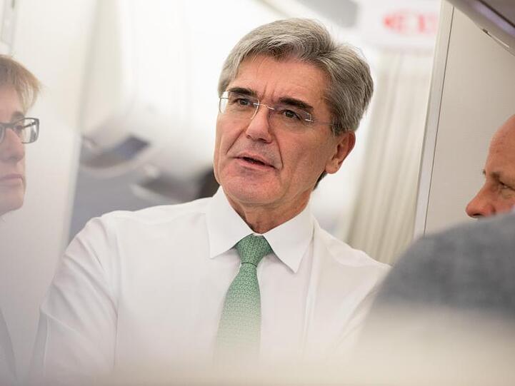 Der Vorstandsvorsitzende von Siemens, Joe Kaeser (M), unterhält sich mit Journalisten. Foto: Kay Nietfeld/Archiv