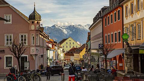 Blick durch die Fußgängerzone Obermarkt in Murnau am Staffelsee mit den Hohen Kisten im Hintergrund.