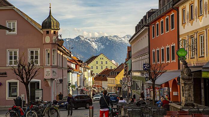Blick durch die Fußgängerzone Obermarkt in Murnau am Staffelsee mit den Hohen Kisten im Hintergrund.