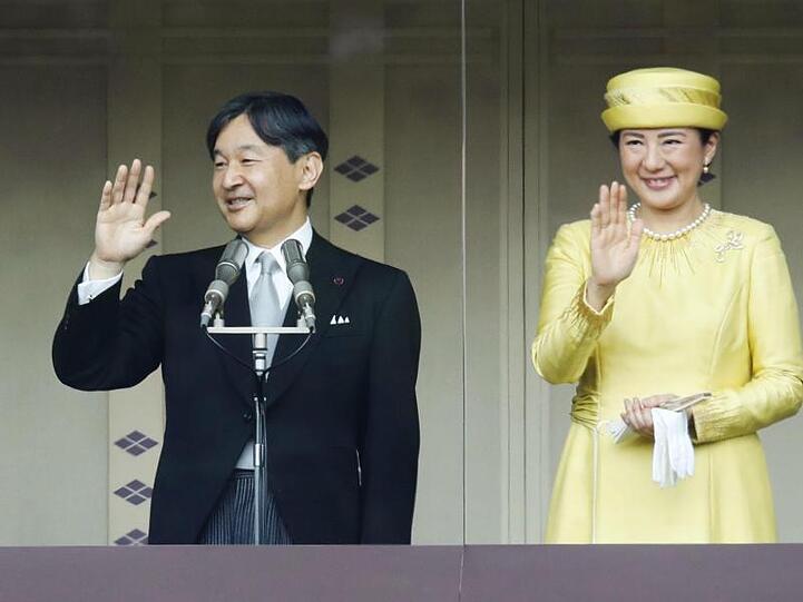 Japans neuer Kaiser Naruhito winkt mit Kaiserin Masako in die Menge.