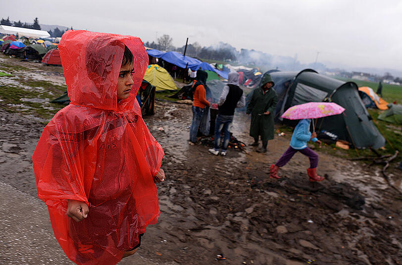 Hunderte Flüchtlinge aus dem Lager in Idomeni durchqueren einen reißenden Fluss auf griechischer Seite, um illegal nach Mazedonien zu gelangen.