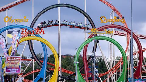 Wiesnbesucher fahren mit der Olympia Looping-Achterbahn.