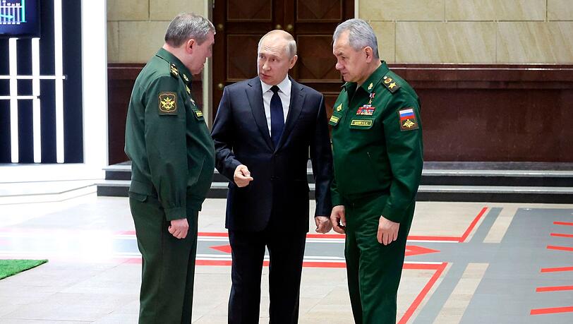 Wladimir Putin (M), Präsident von Russland, im Gespräch mit Waleri Gerassimow (l) Generalstabschef, und Sergej Schoigu, Verteidigungsminister von Russland, nach einem Treffen mit hochrangigen Militäroffizieren.
