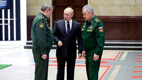 Wladimir Putin (M), Präsident von Russland, im Gespräch mit Waleri Gerassimow (l) Generalstabschef, und Sergej Schoigu, Verteidigungsminister von Russland, nach einem Treffen mit hochrangigen Militäroffizieren.