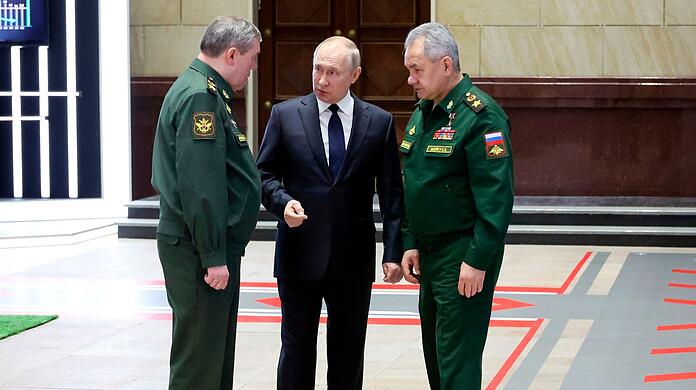 Wladimir Putin (M), Präsident von Russland, im Gespräch mit Waleri Gerassimow (l) Generalstabschef, und Sergej Schoigu, Verteidigungsminister von Russland, nach einem Treffen mit hochrangigen Militäroffizieren.