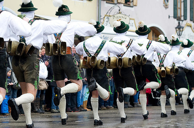 "Schellenrührer" ziehen beim Faschingstreiben durch Mittenwald. Mit dem Lärm der großen Kuhglocken sollen nach altem Brauch die bösen Wintergeister ausgetrieben werden.