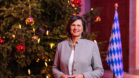 Ilse Aigner steht vor einem beleuchteten Christbaum im Bayerischen Landtag.