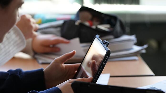 Schüler mit einem Tablet: Den Schulleitungen zufolge fehlt Geld für die Digitalisierung.