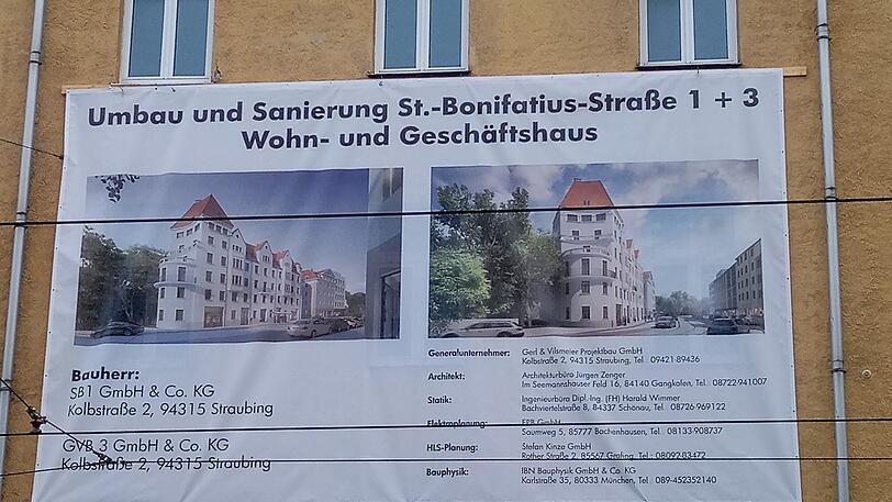 Auf der Bautafel ein Entwurf, wie das Gebäude nach der Renovierung aussehen soll.