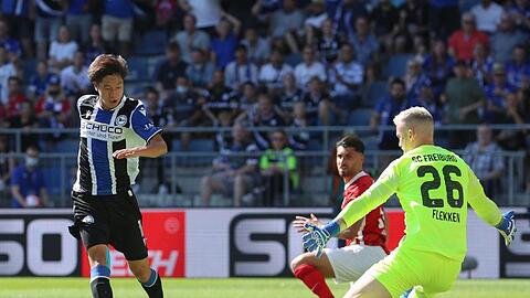 Bielefelds Masaya Okugawa (l) scheitert an Freiburgs Torwart Mark Flekken.