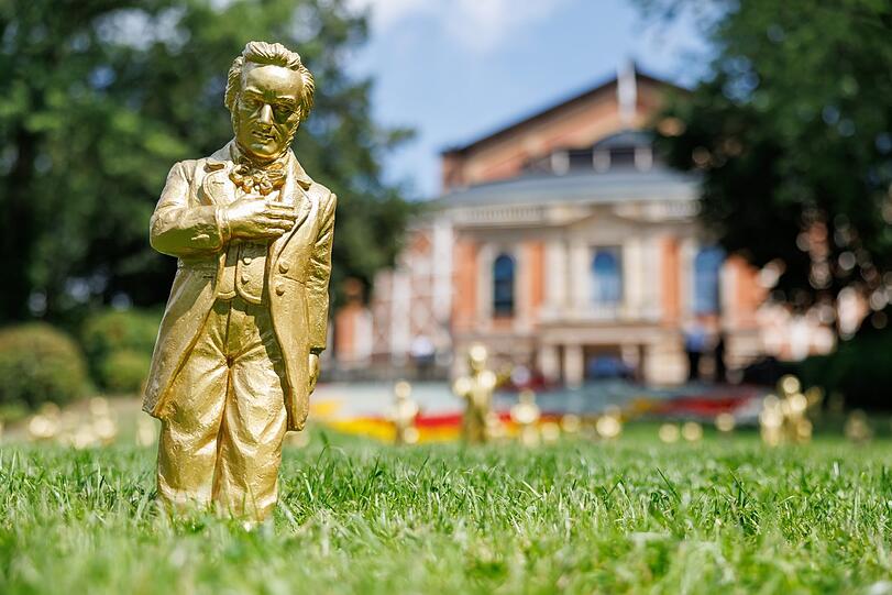 Goldfarbene Wagner-Figuren des Konzeptkünstler Ottmar Hörl vor dem Festspielhaus.
