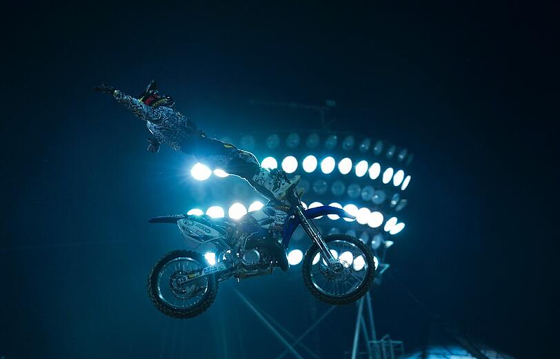Der Freestyle-Motocross-Fahrer Rob Adelberg (Australien) springt beim Qualifying der Red-Bull-X-Fighters Tourstopp an einem Flutlichtmast vorbei.