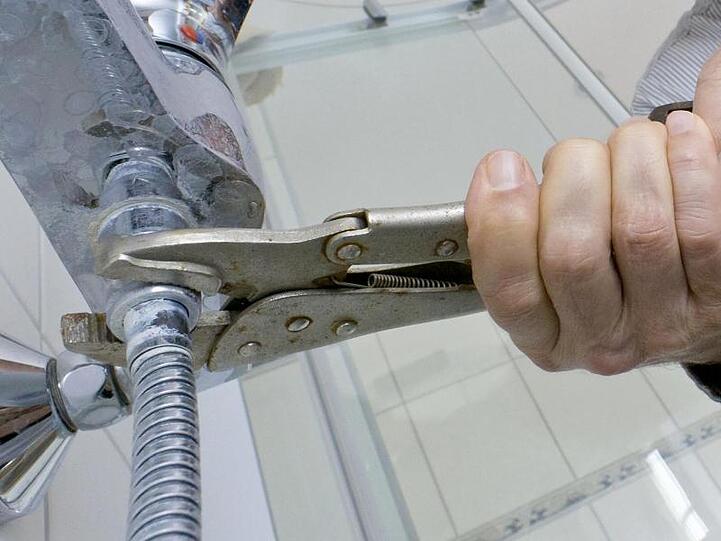 Ein Handwerker arbeitet in einem Badezimmer. Foto: Markus Scholz/dpa-tmn/Symbolbild