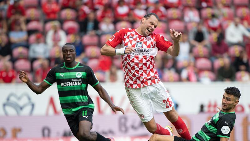Fürths Dickson Abiama (l-r), der Mainzer Ádám Szalai und Fürths Maximilian Bauer kämpfen um den Ball.